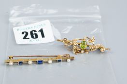 A fifteen carat gold oblong bar brooch with three square cut sapphires and four flanking seed