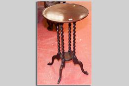 A circular tray top mahogany side table with four barley twist supports and lower central tray on