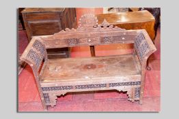 An Eastern hardwood bobbin patterned bench with carved back and curved ends (faded, for restoration)