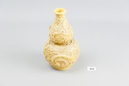 A Chinese ivory coloured double gourd vase with extensive relief decoration of scaly dragons amongst