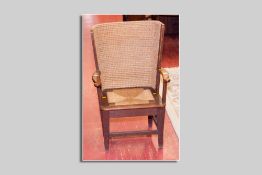 A neat oak framed Orkney style wing chair having scrolled wooden arms, a woven back and a drop-in