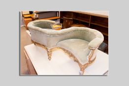 A gilt wood 'S' shaped love seat in green dralon and horse hair upholstery