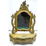 A Venetian toilet-mirror in the Rococo style having a bombe-shaped drawer base and shield shaped
