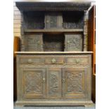 A carved oak tridarn, the base with two cupboards beneath three drawers, the top section with two