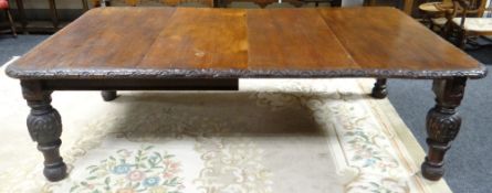 Accompanying Lot 13, an extending carved oak wind-out dining table with two leaf-inserts, 241cms