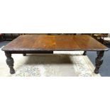 Accompanying Lot 13, an extending carved oak wind-out dining table with two leaf-inserts, 241cms