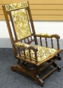 An American rocking chair with upholstered seat and back, circa 1900