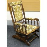 An American rocking chair with upholstered seat and back, circa 1900