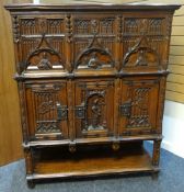 A Jacobean-revival oak court cupboard, the two stages raised above a shelf-base, the upper stage