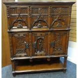 A Jacobean-revival oak court cupboard, the two stages raised above a shelf-base, the upper stage