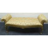 A gilt wood and carved serpentine-fronted window seat in gold covered pictorial upholstery with