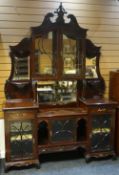 An elaborate mahogany cabinet-sideboard with arrangement of mirrored shelves, integral cabinets,
