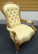 A carved walnut open armchair in yellow patterned buttoned upholstery; together with a carved oak