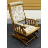 An American rocking chair with upholstered seat and back, circa 1900