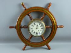 An oak and brass bound six spoke ship's wheel with centre brass framed clock