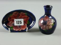 A Moorcroft pottery blue ground 'Anemone' small oval dish and a narrow necked vase, 10 cms high
