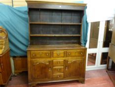 A mid 19th Century Welsh oak dresser having a two shelf rack over a base with two centre opening box