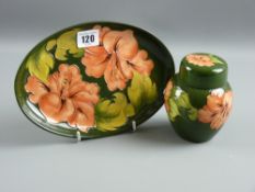 A Moorcroft pottery green ground 'Hibiscus' oval dish, 24 cms long and a lidded pot, 12 cms high