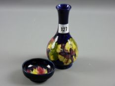 A Moorcroft pottery blue ground 'Freesia' bottle vase, 16 cms high and a small footed dish, 7.5