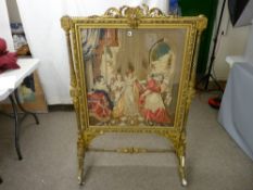 A Victorian gilt wood and gesso firescreen of ornate Rococo style with twist columns and
