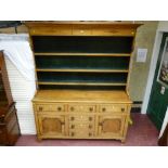 An Anglesey oak straight front dresser, the three shelf rack with diamond decoration and green