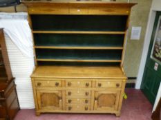 An Anglesey oak straight front dresser, the three shelf rack with diamond decoration and green