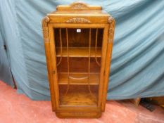 An early 20th Century oak bookcase/cabinet with single beaded glass door and carved decoration,