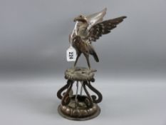 A cast patinated model of a Liver Bird standing with outstretched wings upon a two tier circular