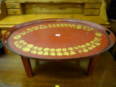 A Regency Toleware twin handled tray having gilt leaf and floral decoration on a red ground set upon
