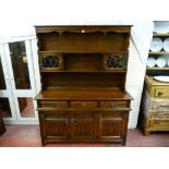 An Old Charm reproduction carved oak dresser with linenfold carved base cupboards, three frieze