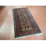 A vintage Eastern wide bordered woollen rug with tasselled ends, 164 x 87 cms, numbered cloth tag to