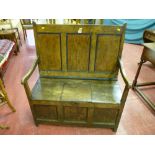 An antique pine and elm box seat settle, a three panel back behind swept arms, central lift-up box