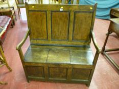 An antique pine and elm box seat settle, a three panel back behind swept arms, central lift-up box