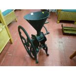 An antique cast iron floor standing grocer's coffee grinder with wooden winding handle, 78 cms high,