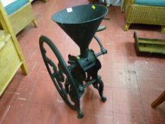 An antique cast iron floor standing grocer's coffee grinder with wooden winding handle, 78 cms high,
