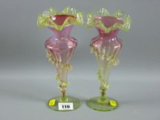 A pair of Victorian vaseline and cranberry glass vases with footed stems and applied frilly