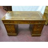 An Edwardian mahogany twin pedestal desk with gilt tooled brown leather skiver, three frieze drawers