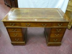 An Edwardian mahogany twin pedestal desk with gilt tooled brown leather skiver, three frieze drawers
