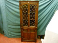 An Old Charm carved oak reproduction corner cupboard with leaded lattice glass doors to the top