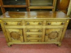 A 19th Century oak crossbanded dresser base with three frieze drawers and two cupboard doors with