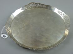A circular plain silver tray with a shaped and pierced border, uninscribed, 36 ozs, London 1917