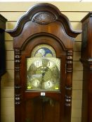 A quality reproduction mahogany triple weight longcase clock with arched brass dial with strike