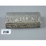 An oblong silver box, the lid decorated with figures in a landscape setting and having an all