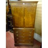 A reproduction walnut and crossbanded two door cupboard with slide tray and four drawer base, all