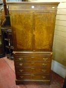 A reproduction walnut and crossbanded two door cupboard with slide tray and four drawer base, all