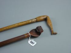 An ash walking cane with carved fruit wood handle in the form of a booted leg having an embossed