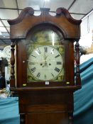 An oak and mahogany 19th Century longcase clock having a domed and scrolled hood with turned columns