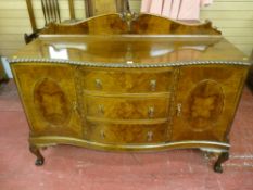 A good quality early 20th Century walnut serpentine front sideboard with decorative back rail,
