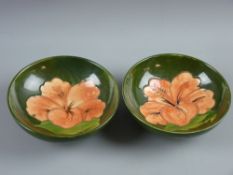 Two Moorcroft pottery 'Hibiscus' green ground bowls, 14 cms diameters on raised shallow foot (