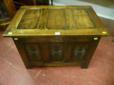 A small polished reproduction miniature dower chest, the lid having three inset panels and the front